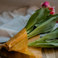 The Cotswold Eco Company Handmade Beeswax Wrap - Yellow Beeswax wrap used to wrap a bunch of pink tulip flowers