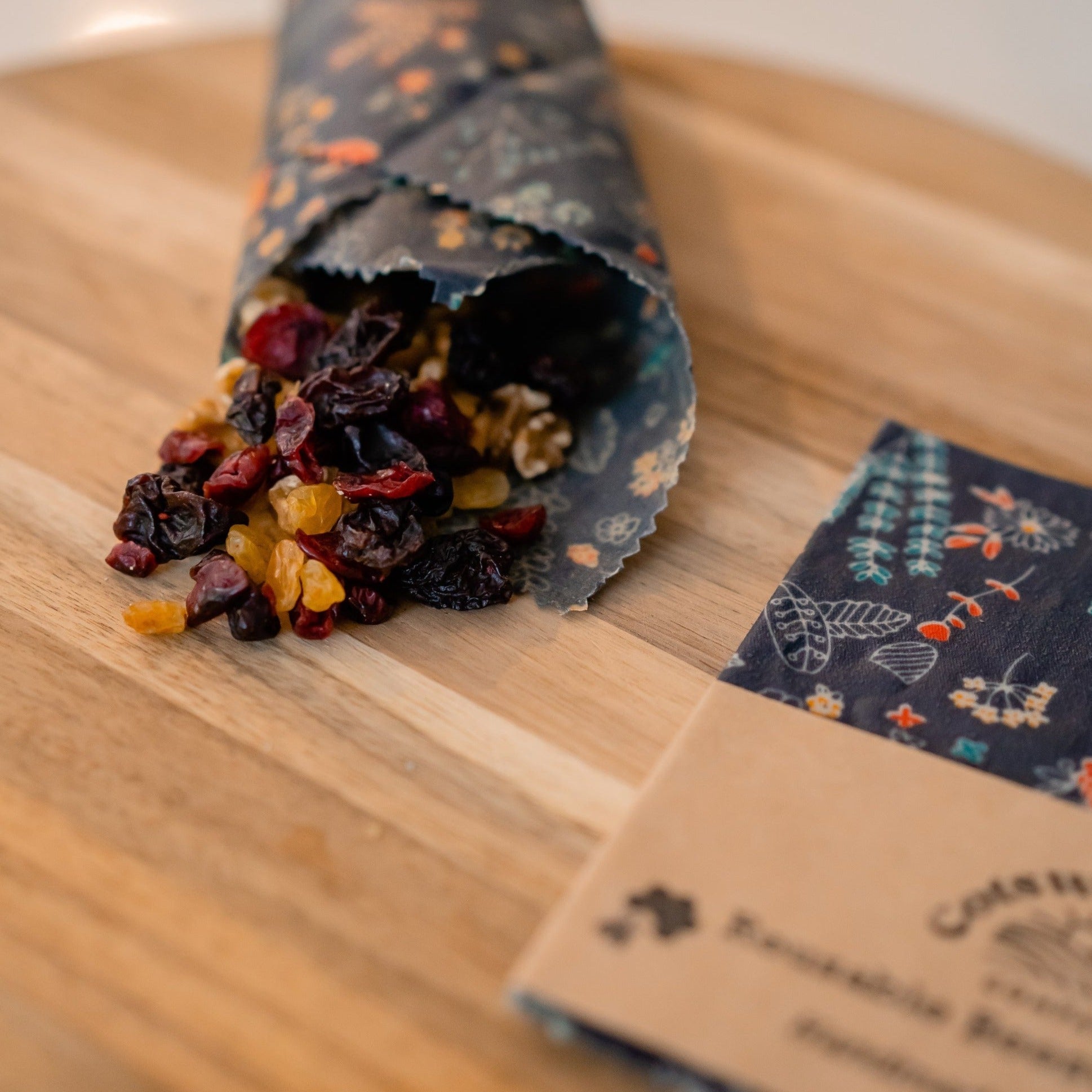 The Cotswold Eco Company Handmade Beeswax Wrap - Navy Blue Floral used as a snack wrap for dried fruit and nuts